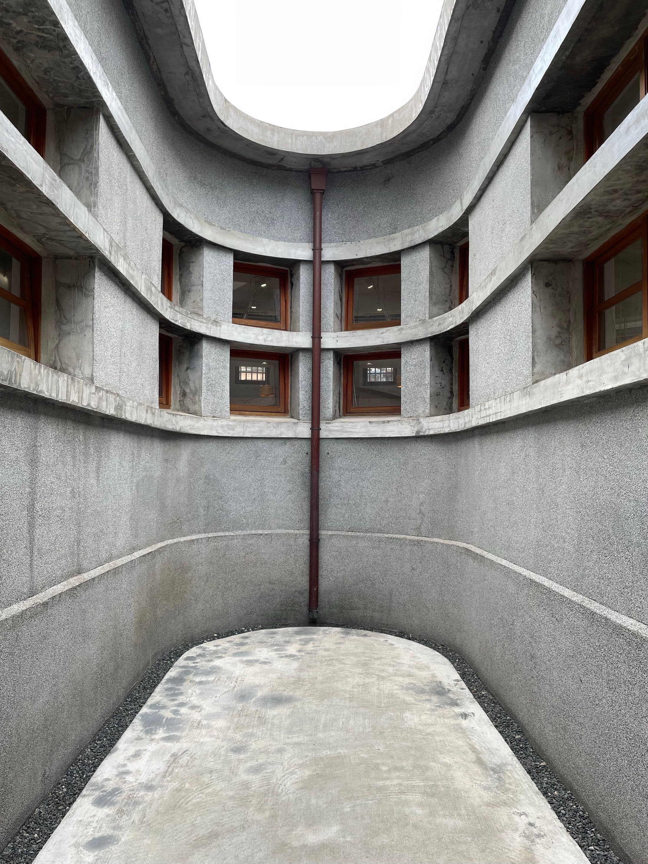 Cour intérieure aux lignes courbes en béton